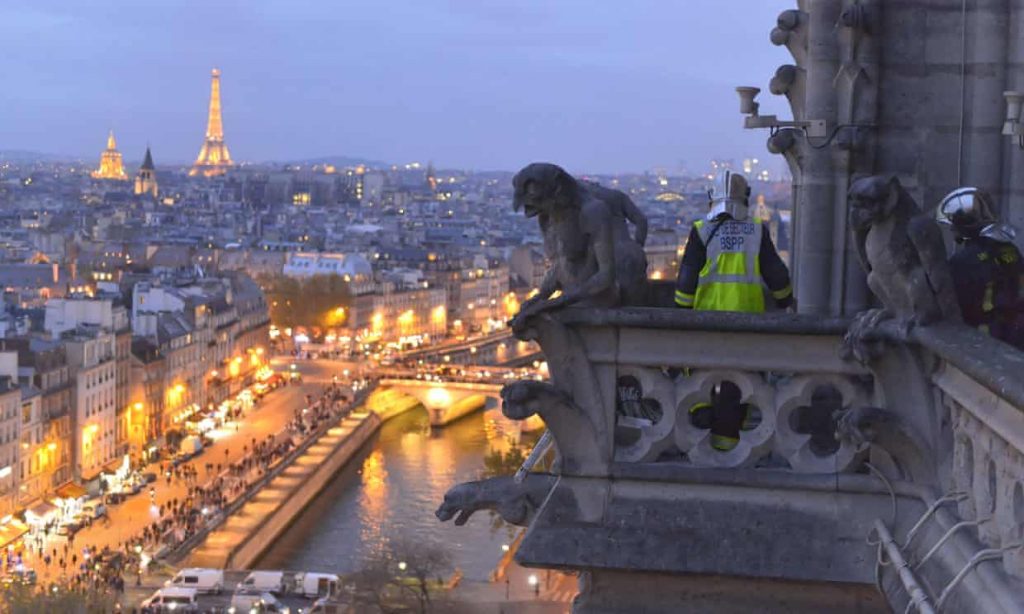 A Pompier Or French Fireman High On Notre Dame