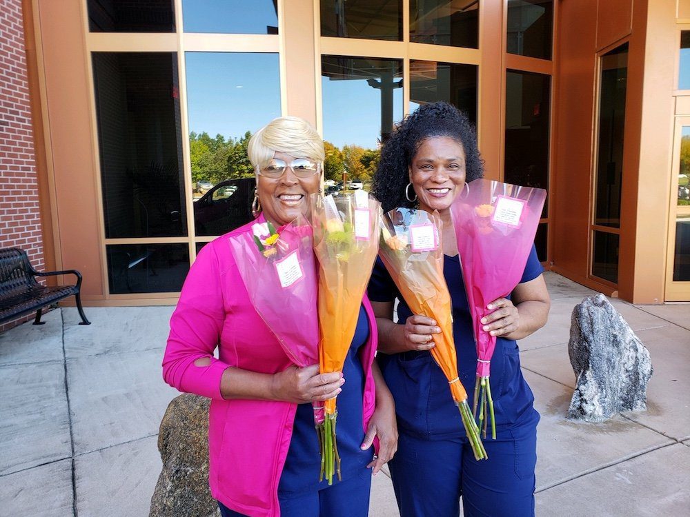 Two women receive free flower bouquets