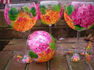 Shop: Four painted wine glasses with flowers on them.