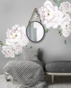 A shop with white flowers on the wall and a mirror.