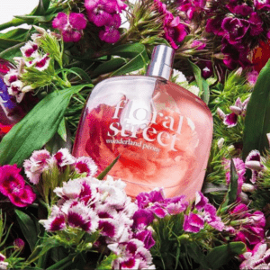 A bottle of floral scent surrounded by flowers.