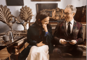 A man and woman sitting on a couch in a living room.